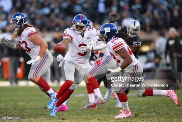 Geno Smith of the New York Giants fakes the handoff to Paul Perkins against the Oakland Raiders during their NFL football game at Oakland-Alameda...
