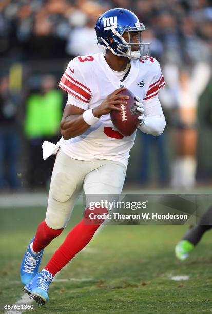 Geno Smith of the New York Giants rolls out to pass against the Oakland Raiders during their NFL football game at Oakland-Alameda County Coliseum on...