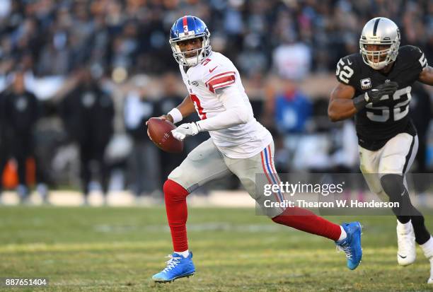 Geno Smith of the New York Giants scrambles away from the pressure of Khalil Mack of the Oakland Raiders during their NFL football game at...