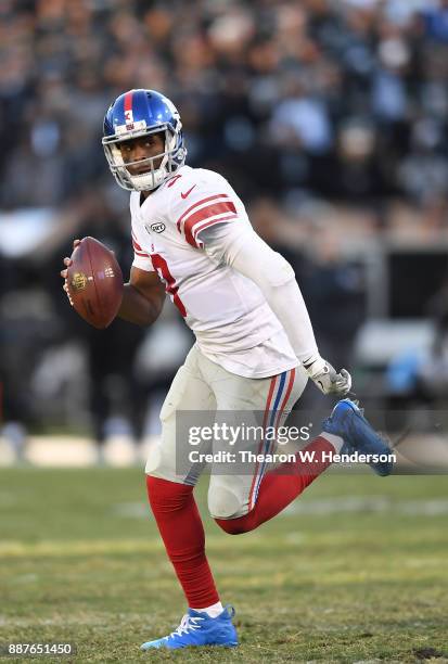 Geno Smith of the New York Giants scrambles with the ball against the Oakland Raiders during their NFL football game at Oakland-Alameda County...