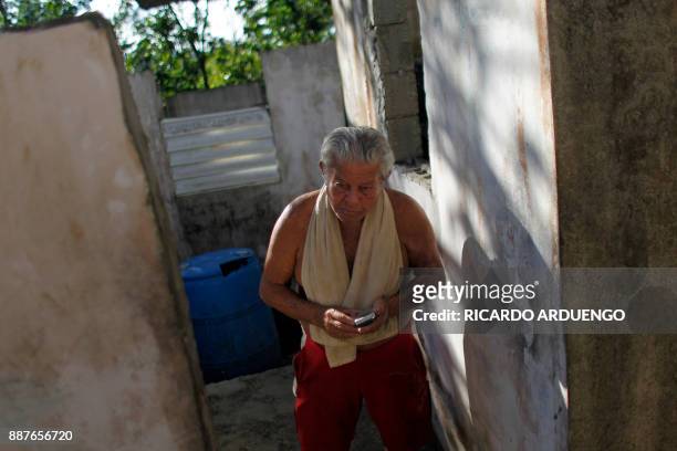 Carmelo Lopez Rivera walks inside his house damaged by Hurricane Maria in Vieques, Puerto Rico on November 26, 2017. / AFP PHOTO / Ricardo ARDUENGO /...