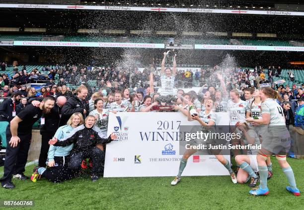 Lara Gibson of Cambridge and her team mates celebrate as they lift the trophy following victory in the Oxford University vs Cambridge University...