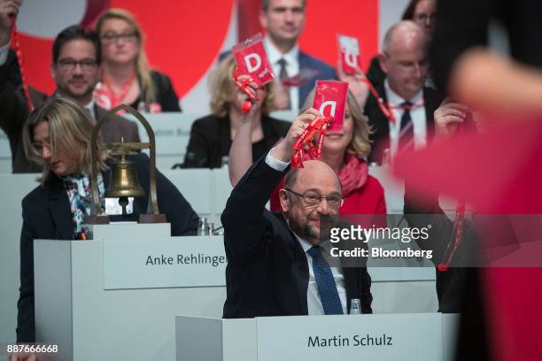 Martin Schulz, leader of the Social Democrat Party , center, raises his hand to vote during the SPD's federal party convention in Berlin, Germany, on...
