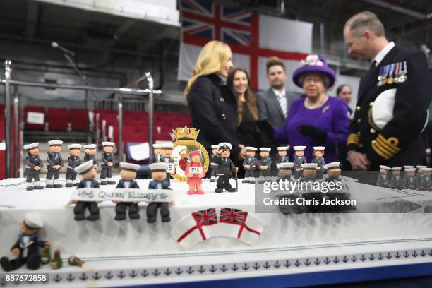 Queen Elizabeth II and Katherine Jenkins look at a cake made by David Duncan during the Commissioning Ceremony of HMS Queen Elizabeth at HM Naval...