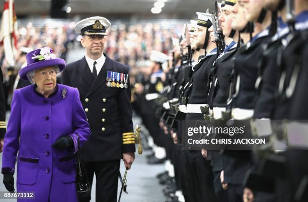 Britain's Queen Elizabeth II inspects the Royal Guard with the ship's commanding officer, Commodore Jerry Kyd as she attends the Commissioning...