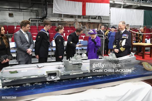 Britain's Queen Elizabeth II views the commissioning cake made by David Duncan for the Commissioning Ceremony for the Royal Navy aircraft carrier HMS...