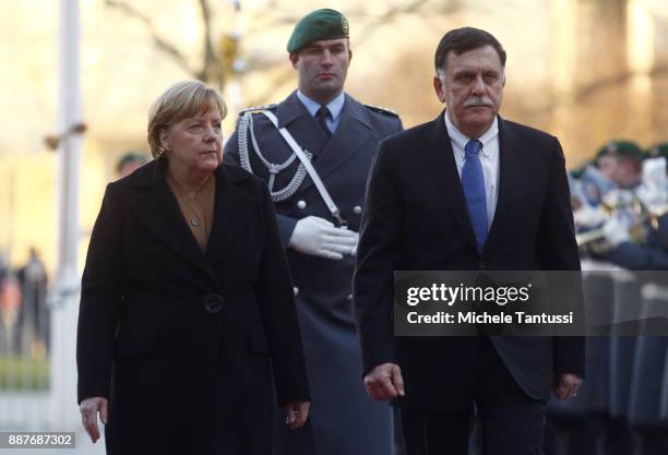 Germany Chancellor Angela Merkel and Chairman of the Presidential Council of Libya and prime minister Fayez Mustafa al-Sarraj pass by the honor guard...