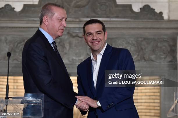 Greek Prime Minister Alexis Tsipras and Turkish President Recep Tayyip Erdogan shake hands after delivering a joint press conference in Athens on...