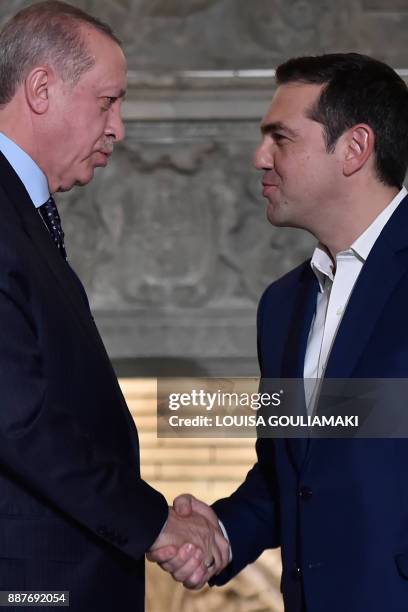 Greek Prime Minister Alexis Tsipras and Turkish President Recep Tayyip Erdogan shake hands after delivering a joint press conference in Athens on...