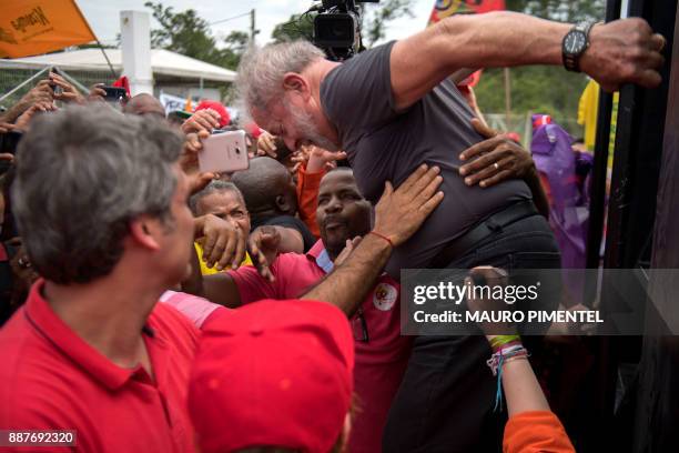 Former Brazilian president Luiz Inacio Lula da Silva, struggles to descend from his bus surrounded by supporters during a presidential pre-campaign...