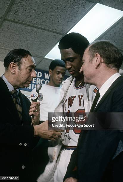 Willis Reed, head coach Red Holzman of the New York Knickerbockers in the locker room is being interviewed by ABC's Howard Cosell after the Knicks...