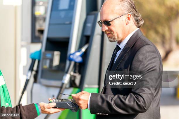 kontaktloses bezahlen in der tankstelle - petrol paying stock-fotos und bilder