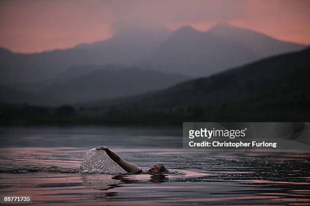 Lady Alice Douglas swims in Llyn Mymbyr at sunset in the shadow of the Snowdon Horseshoe in North Wales on June 30, 2009 in Capel Curig, United...