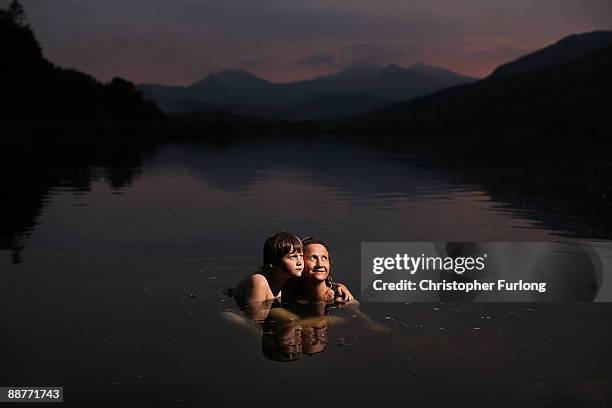 Lady Alice Douglas and her son Tybalt Melia, aged nine, swim at sunset in Llyn Mymbyr in the shadow of the Snowdon Horseshoe in North Wales on June...