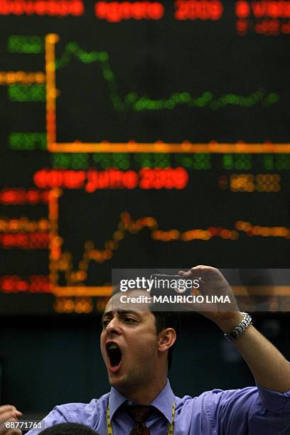 Stock trader yells as he takes a picture of his colleagues after the closing trading session negotiated by traders, at the main floor of the...