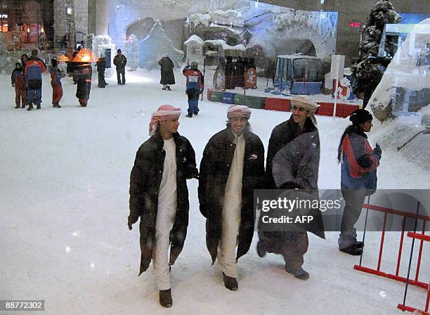 Emarati youths are seen from behind a thick glass enjoying a minus 3 degree Celcius climate at Ski Dubai in the Emirates Mall on July 01 2009. As...