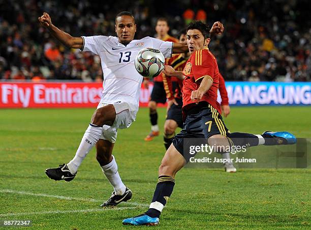 David Villa of Spain challenges Ricardo Clark of the USA for the ball during the FIFA Confederations Cup Semi Final match between Spain and USA at...