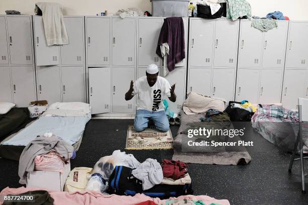 Collen Harris, a practicing Muslim and a displaced resident from the island of Barbuda, prays inside a shelter at a cricket stadium on December 7,...