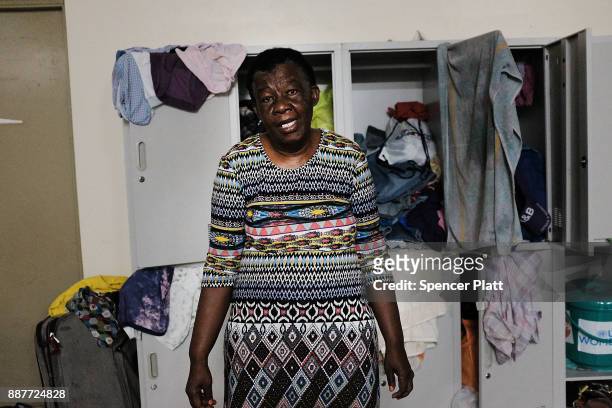 Diane Beazer, a displaced resident from the island of Barbuda, stands inside a shelter at a cricket stadium on December 7, 2017 in St John's,...