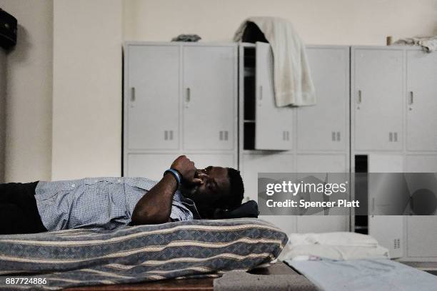 Displaced resident from the island of Barbuda sits inside a shelter at a cricket stadium on December 7, 2017 in St John's, Antiqua. Barbuda, which...