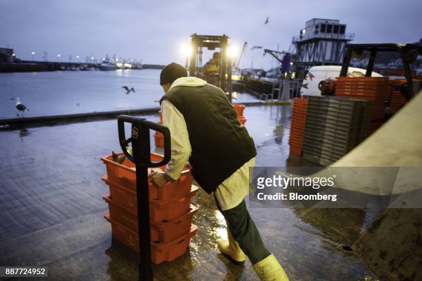Fisherman moves crates of fish at the fish market during the early morning auction at Newlyn harbor in Newlyn, U.K., on Monday, Nov. 27, 2017. Prime...