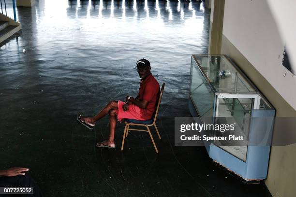 Displaced resident from the island of Barbuda sits inside a shelter at a cricket stadium on December 7, 2017 in St John's, Antiqua. Barbuda, which...