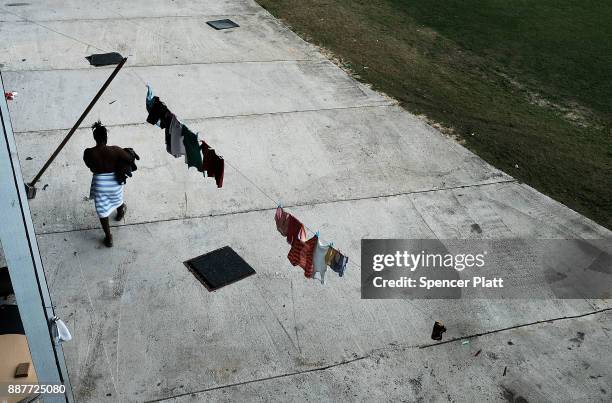 Displaced resident from the island of Barbuda does laundry at a shelter at a cricket stadium on December 7, 2017 in St John's, Antiqua. Barbuda,...