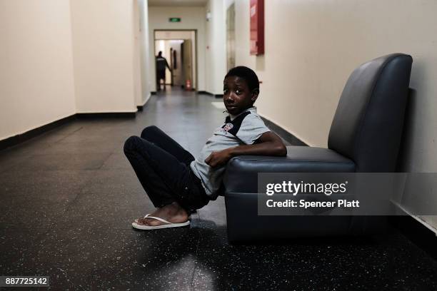 Child, A displaced resident from the island of Barbuda, sits inside a shelter at a cricket stadium on December 7, 2017 in St John's, Antiqua....