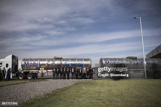 Attendees stand for a photograph in front of a fuel tanker during the unveiling of the Exxon Mobil Corp. Fuel terminal in San Jose Iturbide, Mexico,...