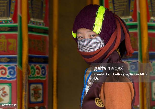 Tibetan pilgrim woman turning huge prayer wheels in Labrang monastery, Gansu province, Labrang, China on October 31, 2017 in Labrang, China.