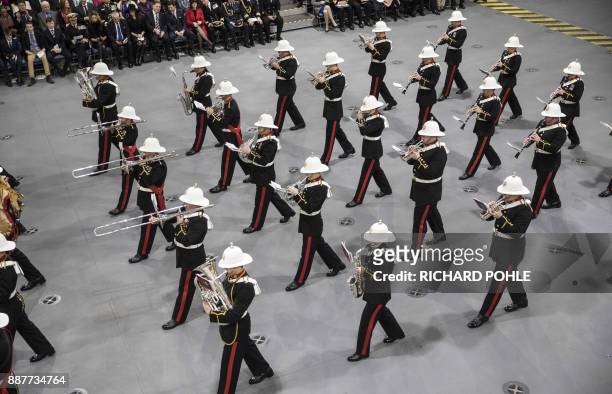 The band of the Royal Marines march onto the hangar deck during the Commissioning Ceremony for the Royal Navy aircraft carrier HMS Queen Elizabeth at...