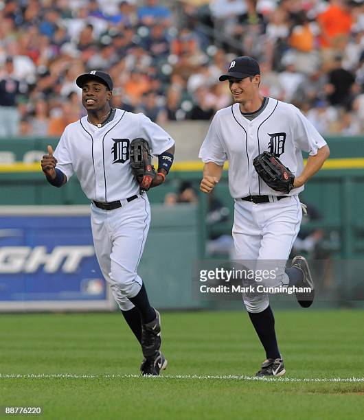 Curtis Granderson and Don Kelly of the Detroit Tigers run off the field against the Chicago Cubs during the game at Comerica Park on June 23, 2009 in...