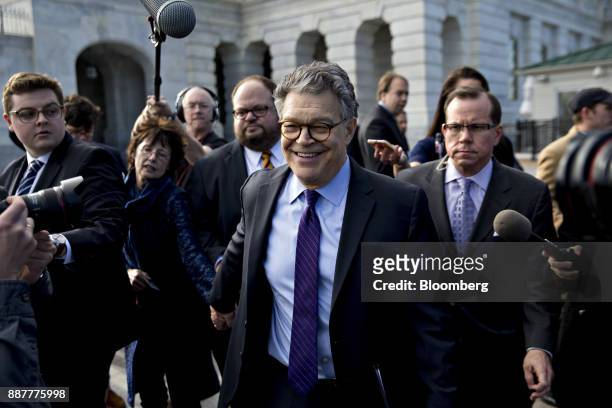 Senator Al Franken, a Democrat from Minnesota, center, walks away from the U.S. Capitol with his wife Franni Bryson, second left, after speaking on...