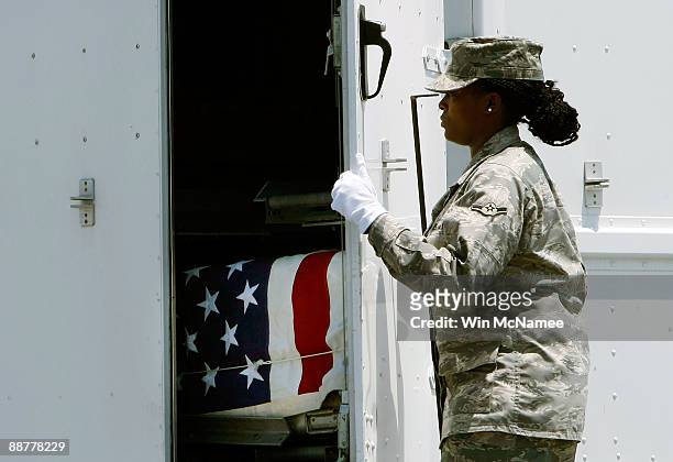 Airman Mercedes McCoy-Garrett closes the door of a transfer vehicle holding the remains of U.S. Army Sgt. Juan C. Baldeosingh following an arrival at...