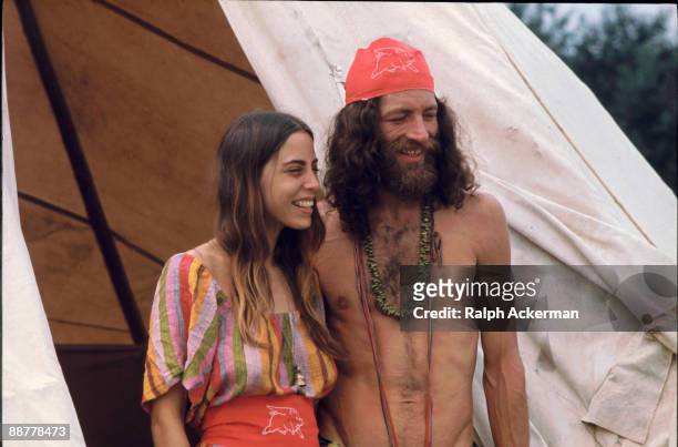 Couple attending the Woodstock Music Festival smiles while standing outside the shelter they've built during the concert, Bethel, NY, August 1969.