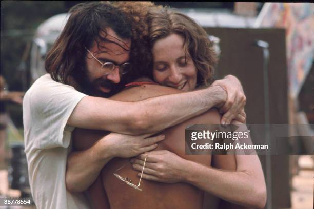 Three men attending the Woodstock music festival hug each other, Bethel, NY, August 1969.