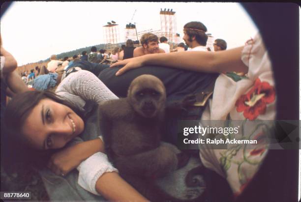 An unidentified girl smiles while her pet monkey sits in the middle of her group at the Woodstock Music Festival, Bethel, NY, August 1969.