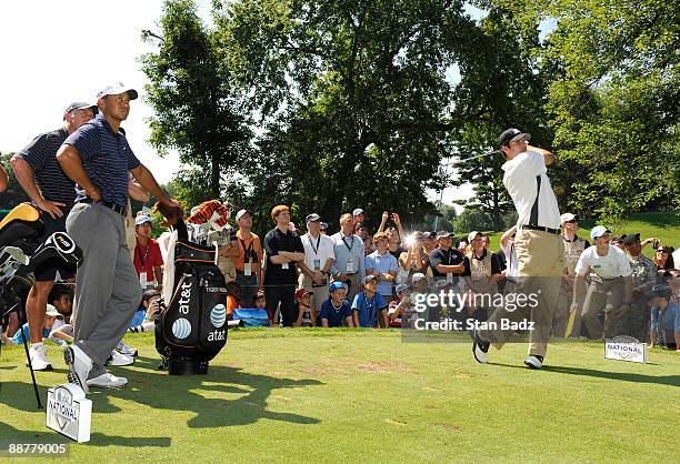 Tiger Woods, left, watches his playing partner Dallas Cowboys Q.B. Tony Romo hit from the seventh tee box during the Pro-Am round for the AT&T...