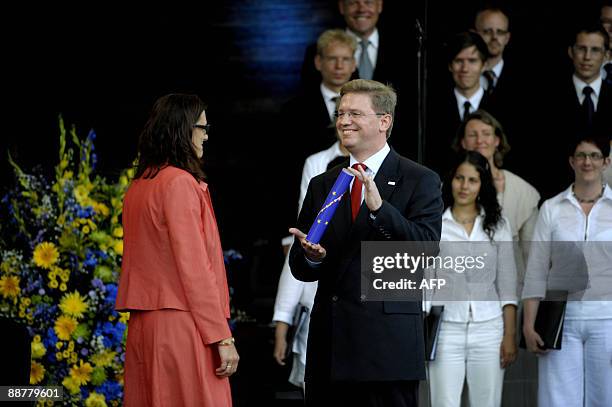 Swedish Minister for EU Affairs Cecilia Malmstrom receives the relay stick from her Czech counterpart Stefan Füle during the evening festivities at...