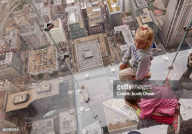 Five -year-old Anna Kane and four-year-old Sophie Allaway check out the view from the Ledge, a new glass cube that juts out from the 103rd floor...