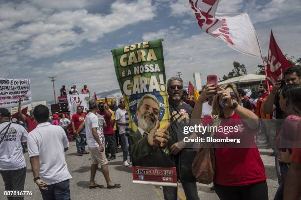 Supporters hold signs during a presidential pre-campaign rally with Brazil's Former President Luiz Inacio Lula da Silva outside the Petroleo...