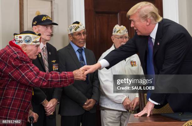 President Donald Trump speaks with Pearl Harbor survivor Lawrence Parry , as he wipes away tears, alongside fellow survivors, during an event marking...