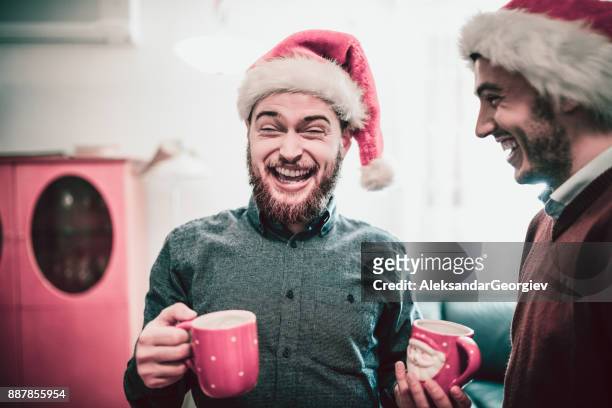 zwei lächelnden freunde trinken kakao und haben eine lustige unterhaltung - christmas coffee stock-fotos und bilder
