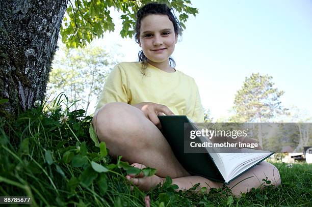 portrait of girl looking up as she reads - vinalhaven bildbanksfoton och bilder