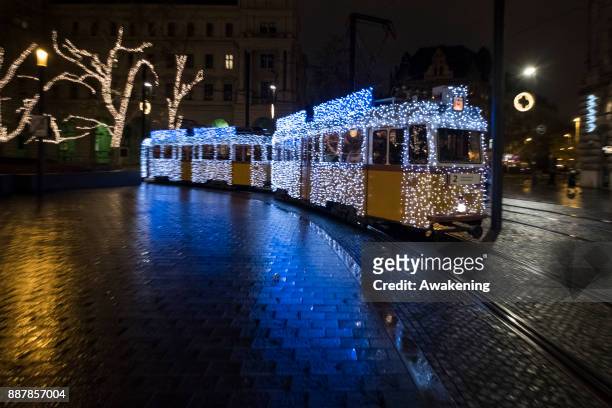 The traditional special festive Christmas lit Tram n2 crosses the square in front of the Hungarian Parliament on December 7, 2017 in Budapest,...