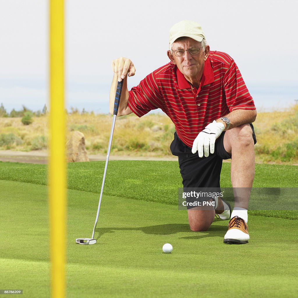 Golfer lines up his shot on the green