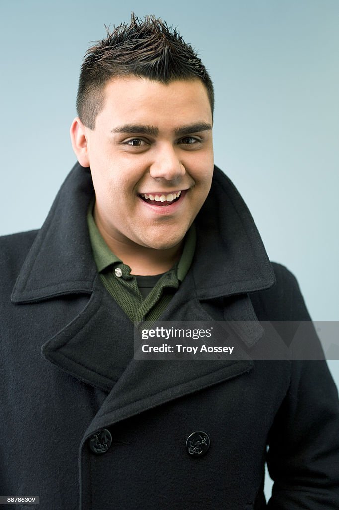 Young man smiling wearing pea coat