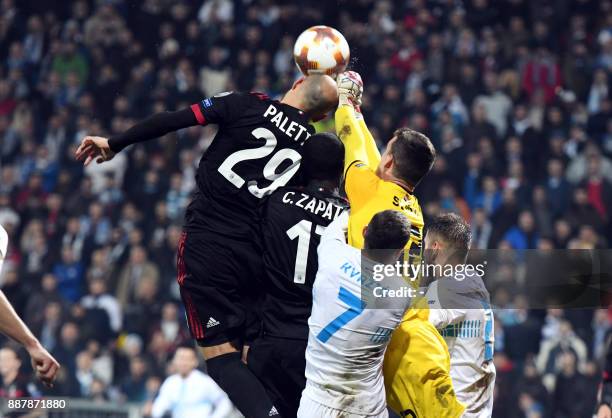 Milan midfielders Gabriel Paletta and Cristian Zapatta jump for the ball with Rijeka's goalkepper Simon Sluga during the UEFA Europa League Group D...