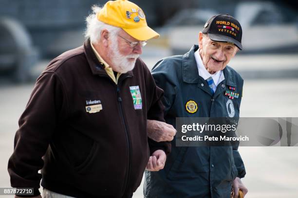 National Park Service volunteer escorts retired Army Master Sgt. Norman Duncan as the Friends of the National World War II Memorial and the National...