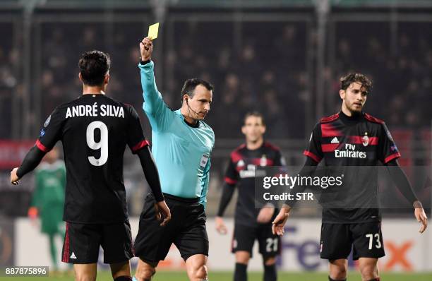 Hungarian referee Istvan Vad shows a yellow card to AC Milan's forward Andre Silva during the UEFA Europa League Group D football match between HNK...